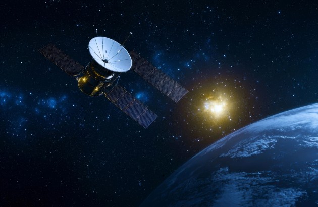 Luft-Raumfahrt-Bild eines Weltraumsatelliten, der die Erde umkreist, vor einem atemberaubenden kosmischen Hintergrund mit Sternen und einem leuchtenden Himmelskörper