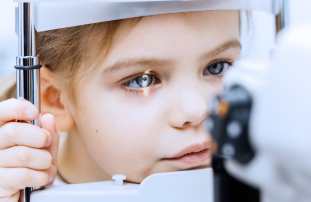 Medizintechnik-Junges Mädchen bei einer Sehuntersuchung mit ophthalmologischen Geräten, mit Schwerpunkt auf der Augenuntersuchung