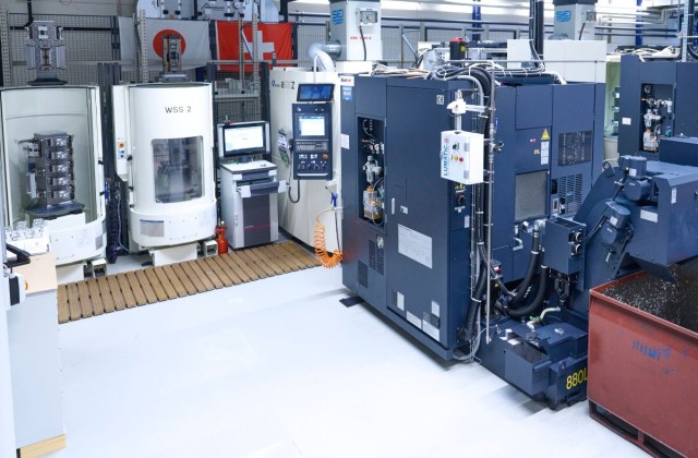 Makino 4 und 5 Achsen Fräsmaschinen stehen in einem Produktionsraum im Hintergrund eine Schweizer und eine japanische Flagge