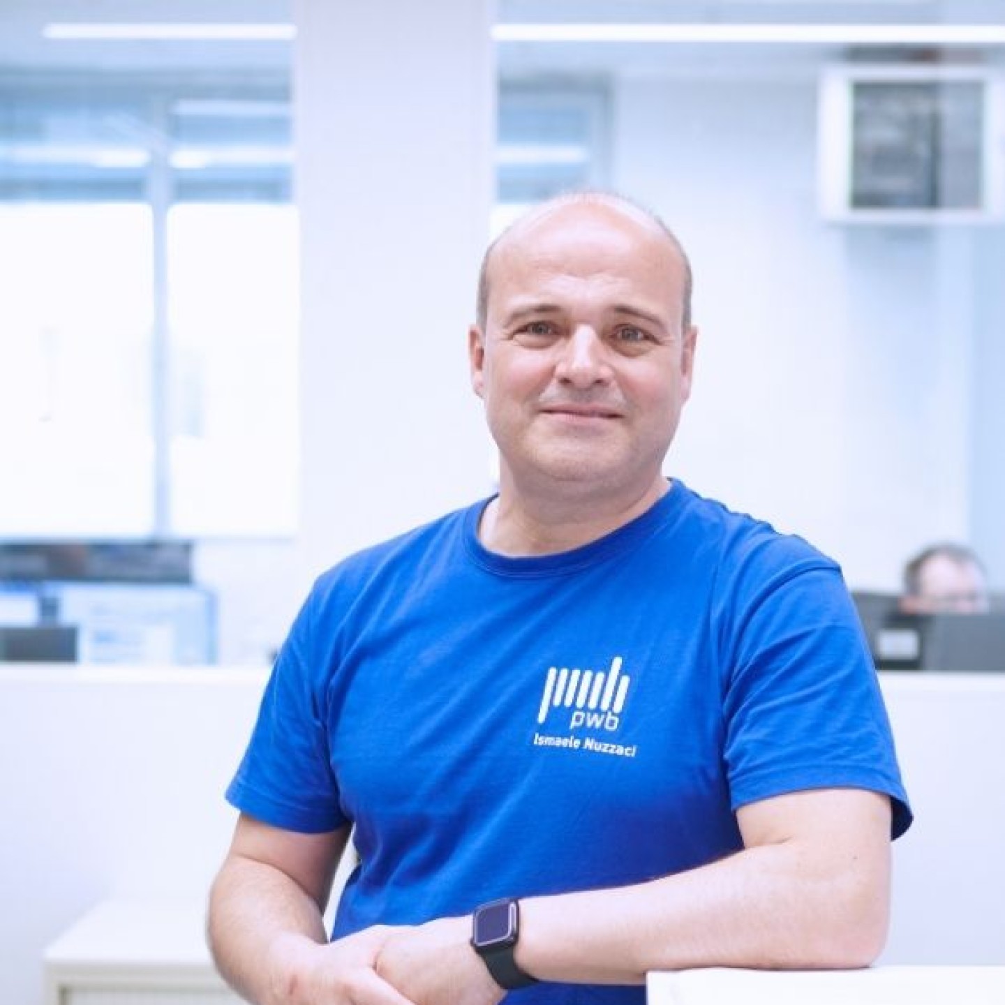 Ismaele Nuzzaci Ausbilder bei PWB AG lehnt in der PWB Academy für mechanische Fertigungstechnik an einem Schreibtisch